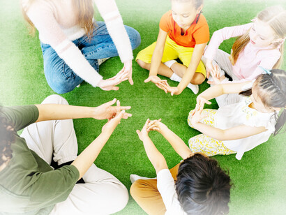 Teachers showing students show children how to stretch out their fingers and hands