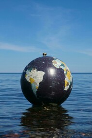 A fragile world adrift; where the fate of the planet floats between calm waters and an uncertain sky