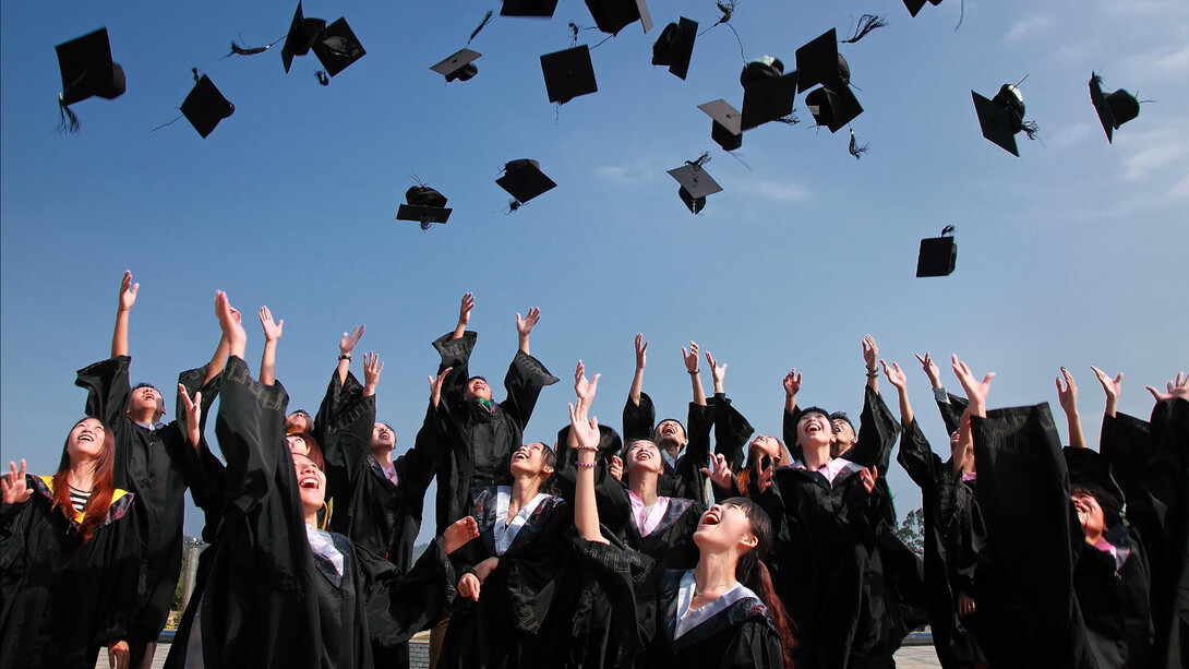 A group of university students posing for a graduation photo