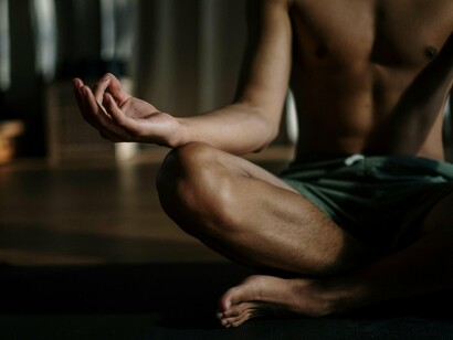 Homem medita. A meditação ajuda a acalmar os pensamentos dispersos e a ansiedade, permitindo que o praticante entre em um estado de atenção mais sereno e receptivo. Isso é essencial para que as memórias e percepções venham à tona com nitidez durante o processo de autoinvestigação



