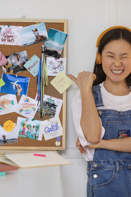 A woman creates a vision board using curated lifestyle images for visual inspiration