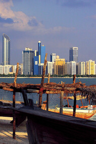 Skyline of Abu Dhabi, UAE, with boats moored at the shoreline 