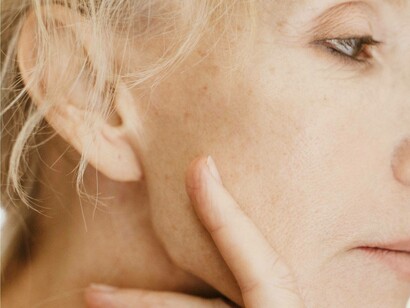 Elderly woman grips her face