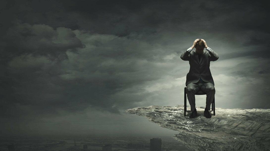 A man stuck in his suffering, sitting on a cliff...