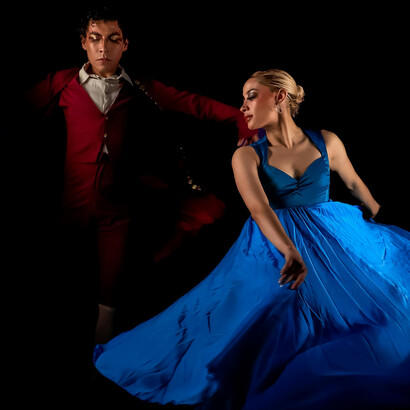 Graceful flamenco dancers illuminated by dramatic lighting, embodying the spirit of Andalusia