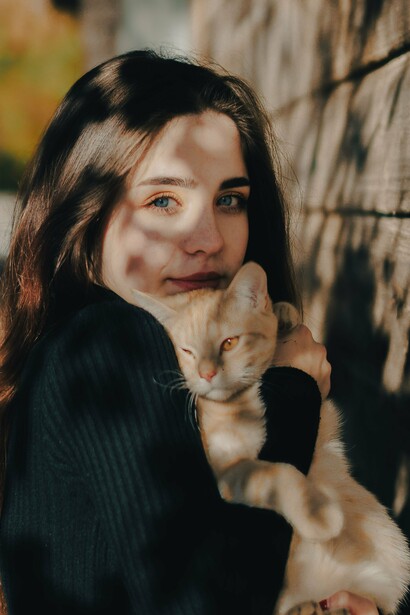 Mulher acaricia um gato em um momento de interação e afeto. A cena estabelece o sentido próprio da palavra “gata” e cria um contraste com seu uso figurado, discutido no artigo como exemplo de desvio do significado convencional das palavras