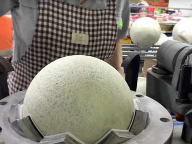 A woman is engaged in the process of producing footballs