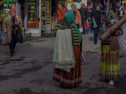 Two elderly women of the Roma are out in the marketplace purchasing goods