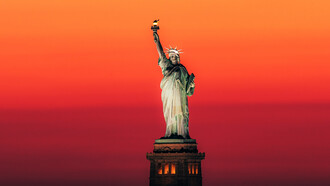 'Estatua de la Libertad' (Arq: Frédéric Auguste Bartholdi y Richard Morris Hunt) en una atardecer en Nueva York, Estados Unidos