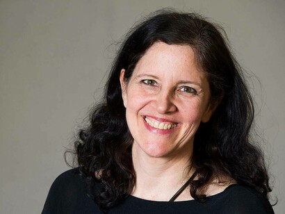 Filmmaker Laura Poitras smiling after winning numerous awards for "all the beauty and all the bloodshed"