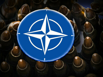 Das NATO-Symbol, umgeben von Militärgeschossen