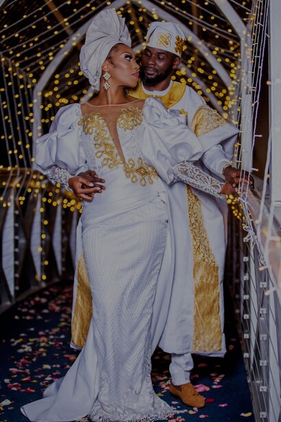 Noivo e noiva posam para foto de casamento com roupas tradicionais angolanas
