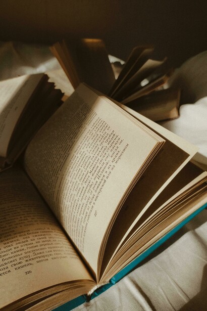 Obras literarias apoyadas sobre una sábana blanca. En distintos textos se pueden encontrar mensajes que buscan destruir