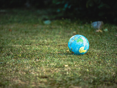 A ball globe of the Earth sits on the green grass