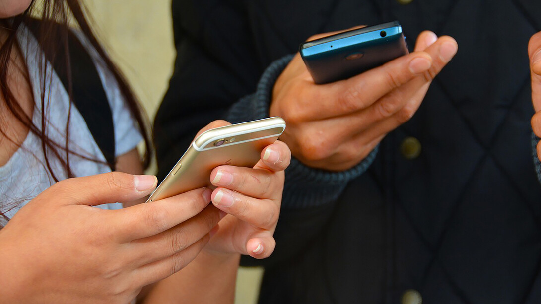 Two individuals utilizing mobile phones and technology