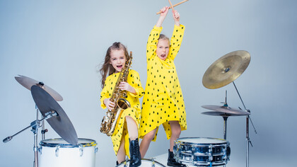 Joyful kids' music band delivers a lively performance in a recording studio, radiating happiness and musical enthusiasm