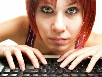 Una mujer escribiendo en un teclado