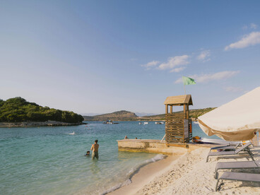 A calm beach day in Ksamil, Albania, turquoise water, soft sand, and peaceful horizons


