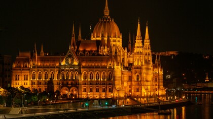 The Hungarian Parliament illuminated at night beside the Danube River, Budapest, Hungary