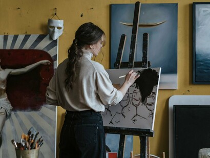 A painter focused on every subtle detail of a portrait, symbolizing the cinematic precision seen throughout Satoshi Kon’s filmography