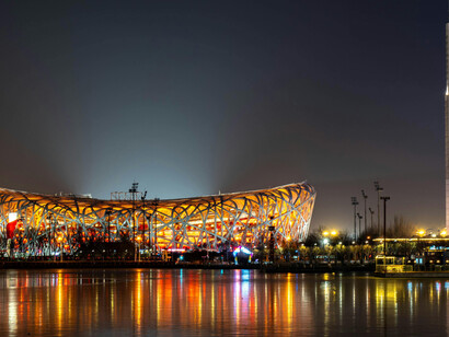 The Beijing National Stadium illuminated at night. Designed by Herzog & de Meuron for the 2008 Olympic Games, the structure is widely known as the “Bird’s Nest” and reflects biomimicry in architecture through its steel framework inspired by the form of a natural nest, Beijing, China