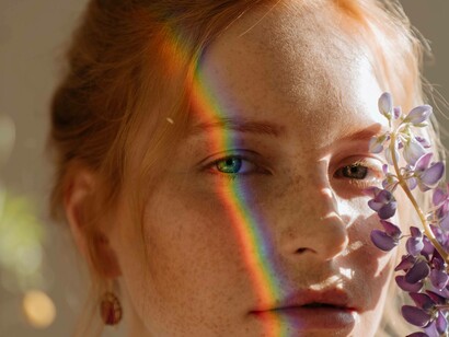 A woman with a rainbow streaking down the right side of her face