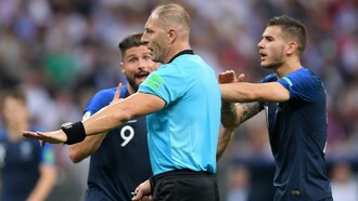 Néstor Pitana, el árbitro de la final del Mundial de Rusia, entre dos jugadores de la selección francesa