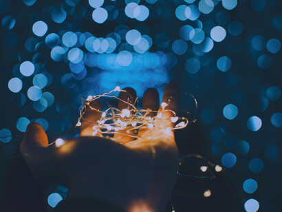 Holding a hand out with light and a magical setting