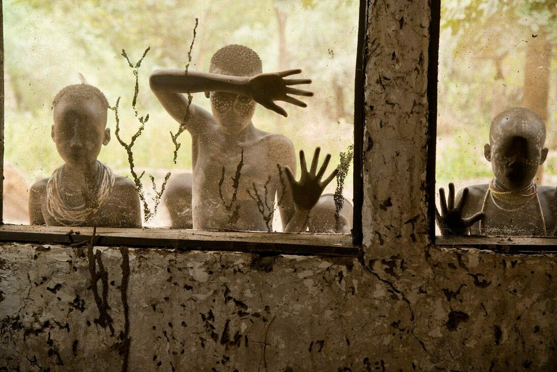 Steve McCurry, Bambini della tribù Kara che guardano attraverso le finestre, Omo Valley, Ethiopia, 2013