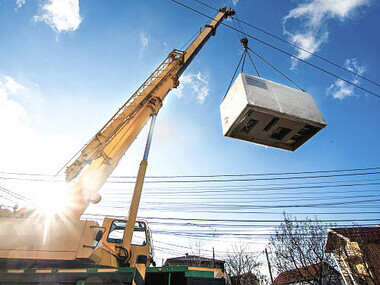 Prefabricated modular wooden commercial building being assembled with a crane for efficient construction