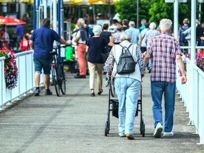 Two male elderly friends walk together over the bridge