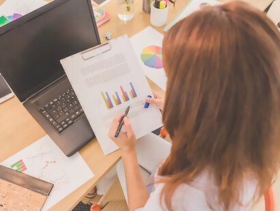 Delve into the world of fashion data management and privacy as a woman navigates through diagrams at her desktop, illustrating the importance of robust data handling practices in market research and safeguarding consumer privacy