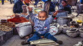 Cina – Bambino al mercato di Turfan (Regione autonoma degli Uygur dello Xinjiang), foto Sergio Pessolano