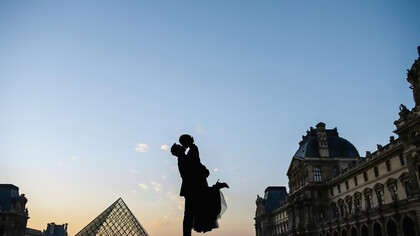 Silhouette of a man lifting a woman in his arms near the Louvre Museum in Paris, France