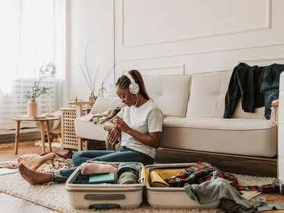 A woman listening to music on her headphones while packing