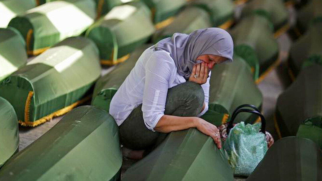 A women crying before a coffin