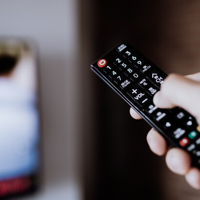 Un mando a distancia frente al televisor representa la relación cotidiana del público con los contenidos audiovisuales y la posibilidad permanente de cambiar de canal