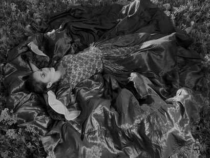 Woman in a flowy dress dreaming in a field