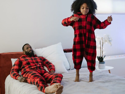 A father and his daughter bond over quality time, donning matching pajamas, as they intentionally step away from phones and social media, creating cherished moments together
