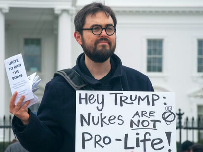 "John Whitehead holds a white sign reading 'Nukes Are Not Pro-Life' during a protest outside the White House, USA