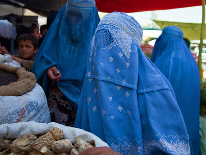Afghan women wearing blue burqas in a bazaar
