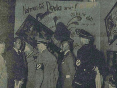 Adolf Hitler and other Nazi officials (Hoffmann, Willrich, Hansen, and Ziegler) standing by the Dada wall at the “Entartete Kunst” (Degenerate Art) exhibition, July 16, 1937. Paintings by Vasily Kandinsky, Paul Klee, and Kurt Schwitters have been deliberately hung askew and are accompanied by a slogan penned by George Grosz. This photo was published in the Nationalist Observer, South German (Süddeutsche) issue, No. 199, July 18, 1937. Staatsbibliothek zu Berlin, Stiftung Preussischer Kulturbesitz, Berlin, Germany. bpk, Berlin, Art Resource, NY