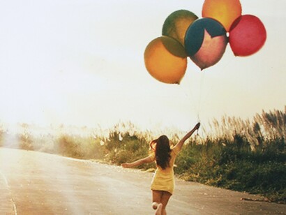 Una chica pasea con unos globos
