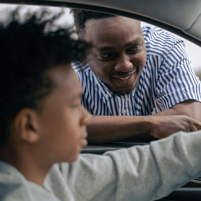 Pai e filho exploram juntos as funções de um carro, fortalecendo laços e alimentando sonhos para o futuro