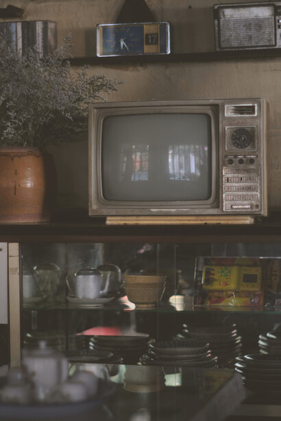 A cozy living room with a vintage TV and warm light pouring through the curtains, capturing a nostalgic mood