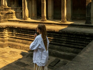Mulher no pátio de Angkor Wat, Siem Reap, Camboja. Confesso que fui para essa viagem — e, consequentemente, para esse destino — sem saber exatamente o que encontraria. Não costumo pesquisar nada sobre os meus destinos de viagem, além do necessário, pois gosto muito de ser surpreendida pelo que irei encontrar. Em um dos dias em que contemplávamos um dos diversos templos do cronograma que tínhamos, fui tomada por uma inquietude. Eu tinha sede de conhecimento, eu queria saber mais, queria poder acessar as outras camadas de uma cultura tão distante da minha