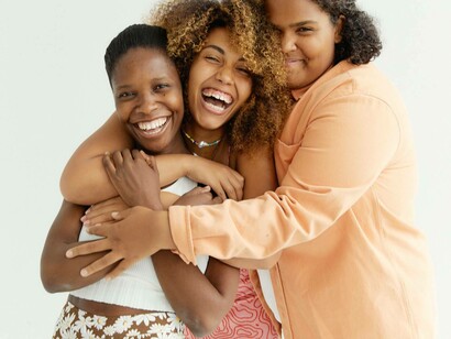 Three friends sharing a group hug to reveal that their friendship is not fake