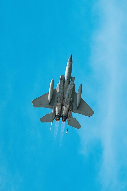 A military fighter jet climbing through a clear blue sky, representing the military power that shaped the Cold War world