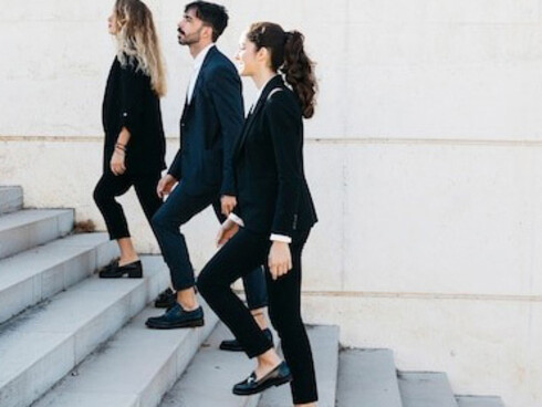 Business people ascending the corporate ladder as they move up the stairs