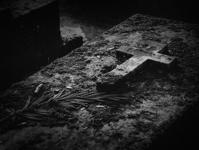 Lápida con una cruz en un viejo cementerio 